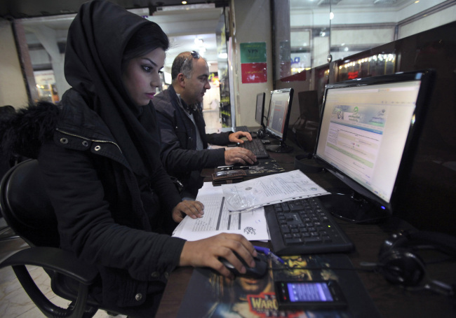 Iranians surf the Web in an Internet cafe at a shopping center in Tehran.   AP-Yonhap News