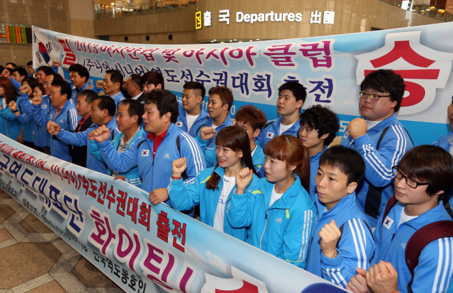 <YONHAP PHOTO-0324> '평양에서 태극기를!', 역도 선수단 출국 (서울=연합뉴스) 최재구 기자 = 북한에서 열리는 2013 아시안컵 및 아시아클럽 역도선수권대회에 출전하는 한국 선수단이 10일 오전 김포공항을 통해 중국 베이징으로 출국하며 선전을 다짐하는 파이팅을 외치고 있다. 선수단은 베이징에서 북한 고려항공편으로 갈아타고 이날 오후 4시께 평양에 도착할 예정이다. 2013.9.10 jjaeck9@yna.co.kr/2013-09-10 09:11:26/ <저작권자 ⓒ 1980-2013 ㈜연합뉴스. 무단 전재 재배포 금지.>
South Korea’s weightlifting team poses for photos on Tuesday.   Yonhap News