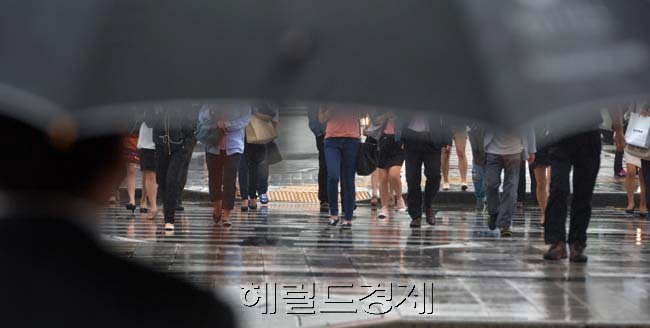 부슬부슬 계절을 재촉하는 비가 내리고 있다. 전국적으로 하루 걸러 하루 비가 내리고 있지만 완연한 가을 날씨는 쉽게 오지 않을 전망이다. 11일 기상청은 비가 그친 뒤로 당분간 예년보다 기온은 높고 강수량은 적은 더운 날씨가 이어질 것이라고 예상했다. 11일 오전 서울 광화문 네거리에서 우산을 든 시민이 종종걸음으로 출근길을 서두르고 있다.