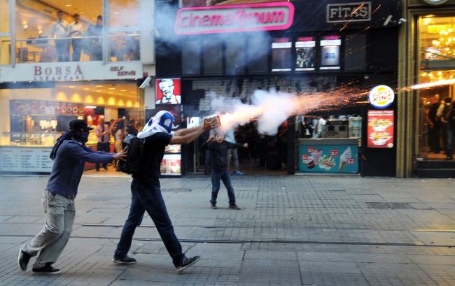 Turkish protesters use fireworks against riot police during clashes in Istanbul on Tuesday.   AFP-Yonhap News