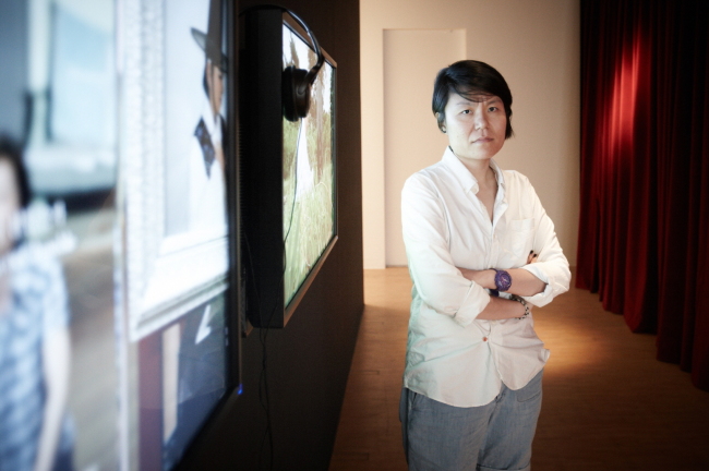 Artist Jung Eun-young, winner of the 2013 Hermes Foundation Art Award, poses in front of her video work at the Maison Hermes in Seoul.   Hermes Foundation