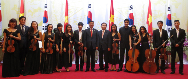 Park Sam-koo (center), chairman of Kumho Asiana, poses with recipients of its scholarships shortly after their concert at a state dinner in Hanoi, Vietnam, Monday.   Kumho Asiana