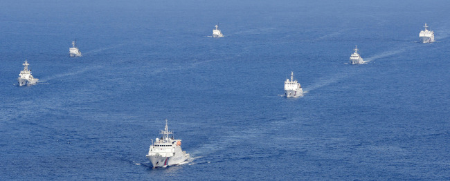 Four Chinese coast guard vessels (right) are followed by Japanese coast guard ships as they intruded into Japan’s territorial waters near the disputed East China Sea islands called Senkaku by Japan and Diaoyu by China Tuesday afternoon.   AP-Yonhap News