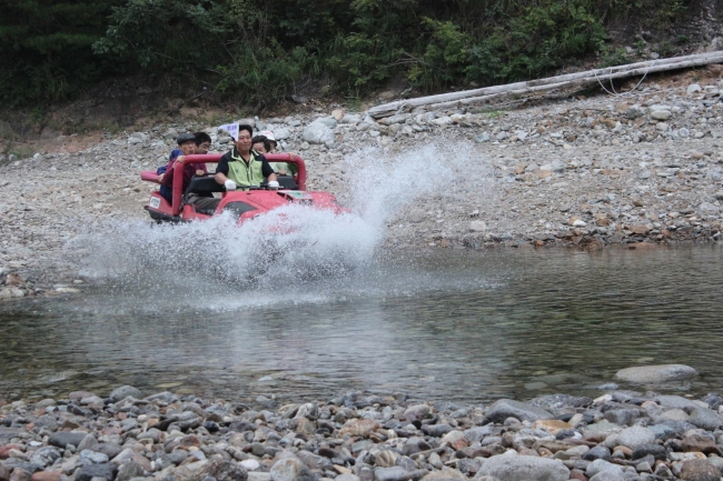 Son Tae-yeong takes visitors on a ride in an amphibious ATV through a creek at Haedam Village’s rural experience camp in Yangyang County, Gangwon Province, on Sept. 5.    Mode Tour