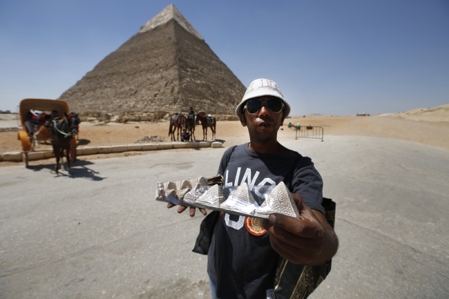 A vendor offers souvenirs for sale to tourists at the historical site of the Giza Pyramids, near Cairo, Egypt on Sept. 7. Riots and killings after the ouster of President Mohammed Morsi have  delivered a severe blow to Egypt’s tourism industry. Tourism had recently accounted for more than 11 percent of the country’s gross domestic product and nearly 20 percent of its foreign currency revenue. (AP-Yonhap News)