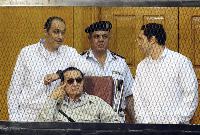 <YONHAP PHOTO-0910> ALTERNATE CROP OF CAI102 -- Former Egyptian President Hosni Mubarak, seated, and his two sons Gamal Mubarak, left, and Alaa Mubarak, right, attend a hearing in a courtroom at the Police Academy, Cairo, Egypt, Saturday, Sept. 14, 2013. Egypt's ousted long-time autocrat was back in court Saturday, grinning and waving for the resumption of his retrial on charges related to the killings of some 900 protesters during the 2011 uprising that led to his ouster. (AP Photo/Ahmed Omar)/2013-09-14 21:28:09/ <저작권자 ⓒ 1980-2013 ㈜연합뉴스. 무단 전재 재배포 금지.>
Former Egyptian President Hosni Mubarak (seated) and his two sons Gamal Mubarak (left) and Alaa Mubarak (right) attend a hearing in a courtroom at the Police Academy in Cairo on Saturday.   AP-Yonhap News