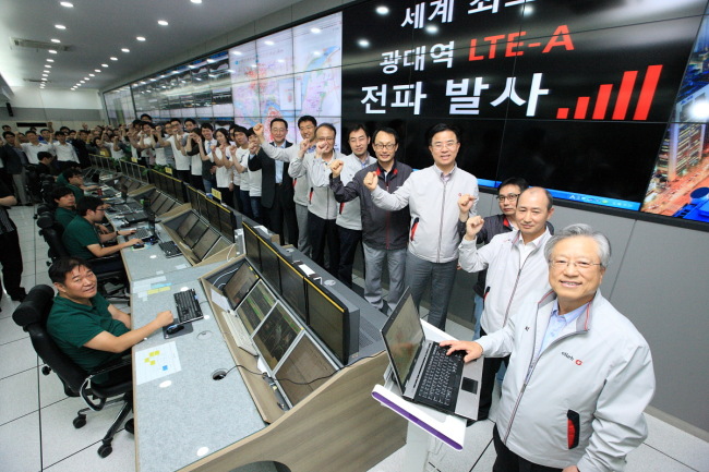 KT chairman Lee Suk-chae (right) and company staff attend a ceremony to launch the commercial service for “Wideband LTE-A” at its network center in Gwacheon, Gyeonggi Province, on Saturday.   KT