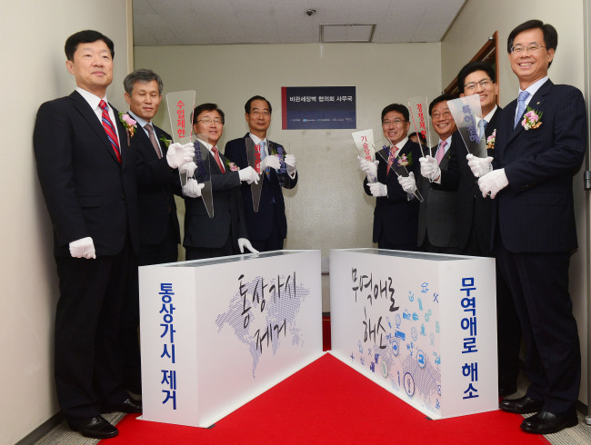 Trade Minister Yoon Sang-jick (fourth from right) and Korea International Trade Association chairman Han Duck-soo (fifth from right) attend a ceremony to open a new office specifically tasked with dealing with non-tariff trade barriers raised by other countries inside the Trade Tower in Samseong-dong, Seoul, Monday. The new organization will be headed by a vice trade minister.   Kim Myung-sub/The Korea Herald