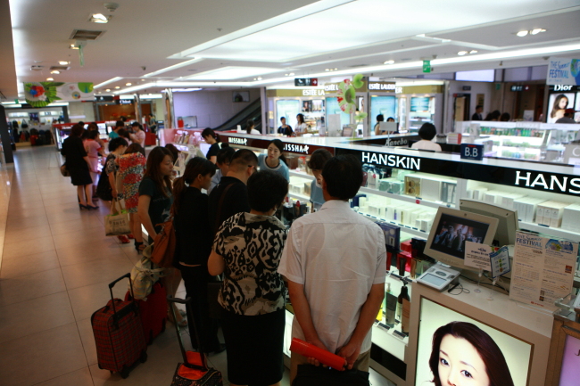 Chinese tourists shop for duty-free Korean beauty products at the Lotte Duty Free COEX store in Samseong-dong, Seoul.    KTO