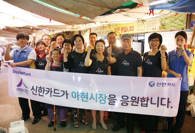 신한카드는 16일 오후 아현시장을 방문해 상인회에 아현시장 브랜드 로고가 새겨진 앞치마 230여벌을 전달했다. 아현시장 상인회원들이 앞치마를 두르고 신한카드 직원들과 기념사진을 찍고있다. [사진제공=신한카드]