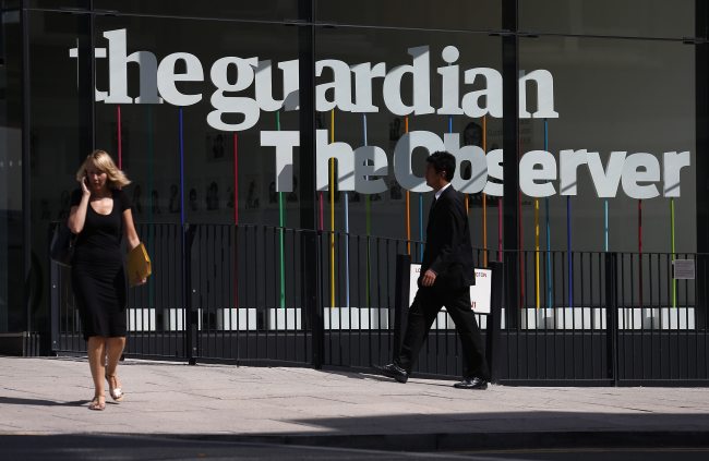 Pedestrians walk past the entrance of the Guardian newspaper building in London. (Reuters-Yonhap News)