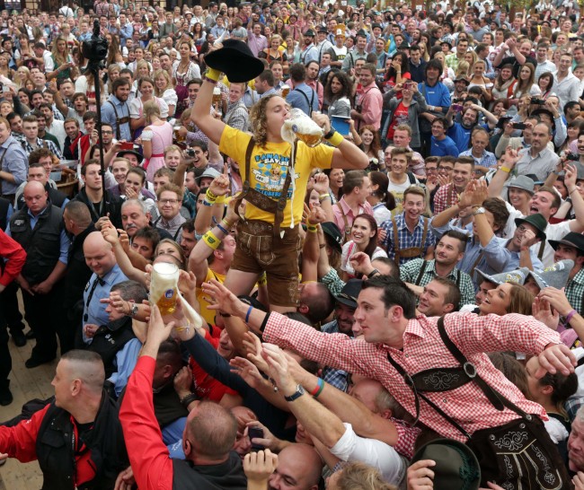 Young people celebrate the opening ceremony in the “Hofbraeuzelt” beer tent of the 180th Bavarian “Oktoberfest” beer festival in Munich, southern Germany, Saturday.   AP-Yonhap News