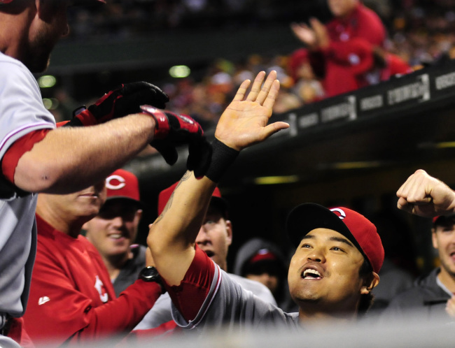 Cincinnati Reds center fielder Choo Shin-soo (right) high fives Zack Cozart following his solo homer in the second inning against the Pittsburgh Pirates at PNC Park in Pittsburgh on Saturday.    UPI-Yonhap News