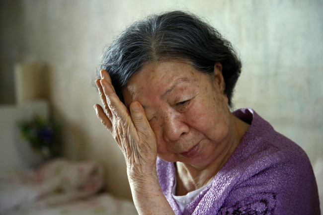 A South Korean elderly woman who was to meet her seperated family in North Korea wipes her tears after Pyongyang postpones the reunions.(Yonhap News)