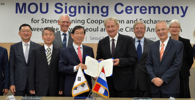 Seoul Mayor Park Won-soon (fourth from left) and his Amsterdam counterpart Eberhard van der Laan (fourth from right) pose at City Hall on Monday after signing a memorandum of understanding, promising to tighten cooperation and share policies in diverse fields including culture, transportation and water management.
Lee Sang-sub/The Korea Herald