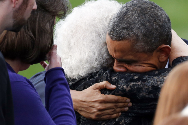 버락오바마(BarackObama/정치인/미국대통령)
U.S. President Barack Obama hugs a family member at a memorial service for the victims of the Washington Navy Yard shooting at the Marine Barracks in Washington on Sunday.   AP-Yonhap News