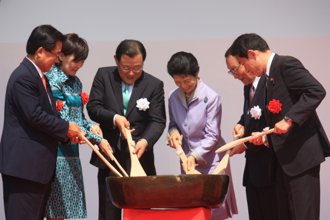 Participants make bibimbap, a popular Korean dish, together in the opening ceremony of the Korea Japan Festival 2013 at Hibiya Park in Tokyo on Saturday. Among them are Kim Tae-whan (left), a lawmaker of the Saenuri Party, Japanese Prime Minister Shinzo Abe’s wife Akie Abe (second from left), South Korean Ambassador to Japan Lee Byung-kee (third from left), Princess Takamadonomiya (fourth from left) and Japanese Foreign Minister Fumio Kishida (sixth from left).   Yonhap News