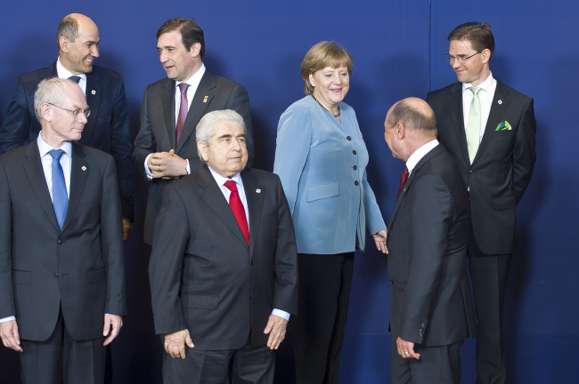 European Council President Herman Van Rompuy (left) and German Chancellor Angela Merkel (third from right) gather for a photograph during the European Leaders summit at the European Council headquarters in Brussels on May 23, 2012.    Bloomberg