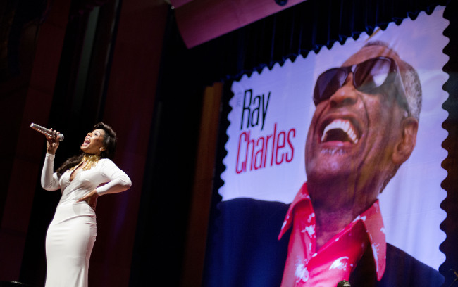 A stamp featuring musician Ray Charles is unveiled as singer Ashanti performs at the event at Morehouse College in Atlanta on Monday.   (AP-Yonhap News)