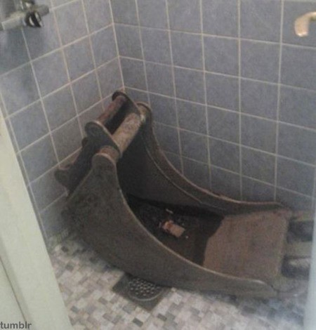 최근 한 온라인 커뮤니티 게시판에는 ‘샤워실의 중장비 미스터리’라는 제목으로 사진 한 장이 올라왔다. 사진에는 샤워실로 보이는 곳 한쪽 구석에 굴착기로 보이는 중장비 일부가 놓여있는 모습이다.