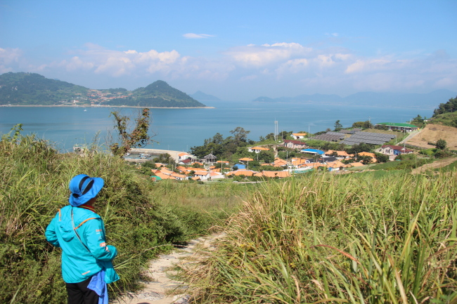 A local guide basks in the view of a quaint village on Yeosu’s Hahwado Island in South Jeolla Province. (Julie Jackson/The Korea Herald)