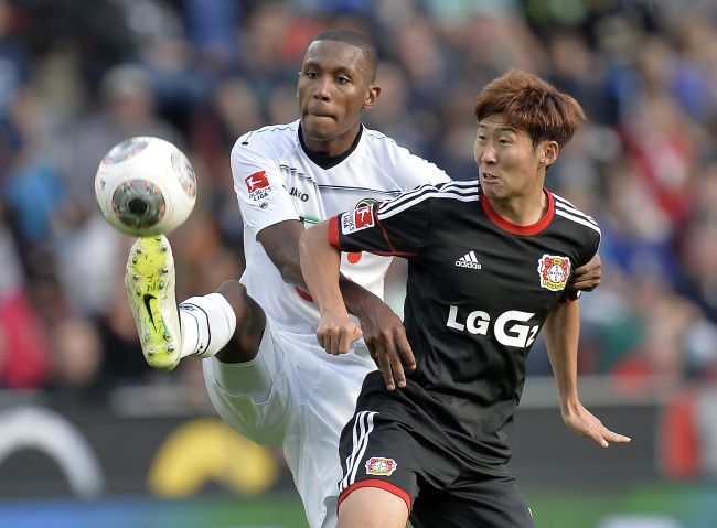 Bayer Leverkusen’s Son Heung-min (right) and Hannover’s Marcelo challenge for the ball on Saturday.   (AP-Yonhap News)