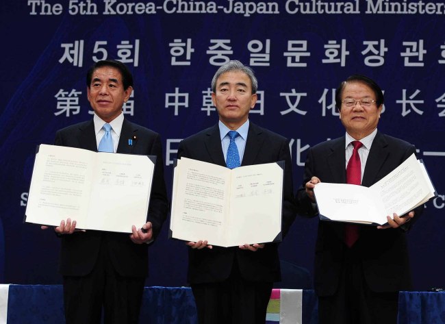 Korean Culture Minister Yoo Jin-ryong (center), Chinese Culture Minister Cai Wu (right) and Japanese Culture Minister Hakubun Shimomura hold the joint agreement after the fifth Korea-China-Japan Cultural Ministers Meeting held in Gwangju on Saturday.   (Yonhap News)