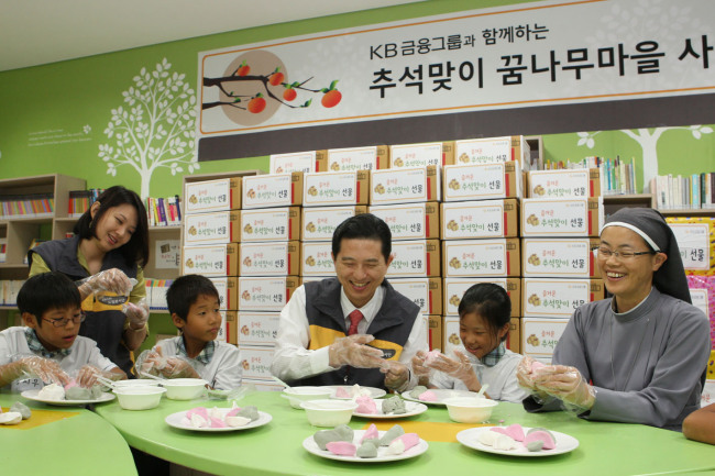 KB Financial Group chairman Lim Young-rok makes songpyeon, a half-moon-shaped rice cake, with children residing at a social foundation in Eungam-dong, Seoul, after donating some daily necessities on Sept. 13. (KB Financial)