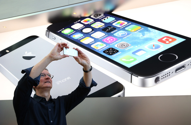 Apple CEO Tim Cook uses an iPhone to take a picture of customers waiting in front of an Apple store to purchase the new iPhones in Palo Alto, California, Sept. 20.   (AFP-Yonhap News)
