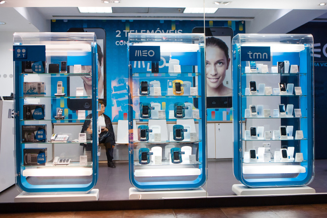 Mobile devices and terrestrial phone handsets sit on display inside a Portugal Telecom SGPS SA mobile communications store in Lisbon on Wednesday.   (Bloomberg)