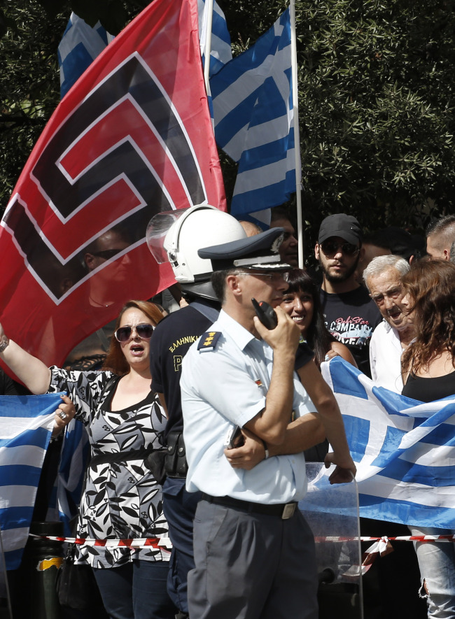Supporters of the extreme far-right Golden Dawn party with Greek and party flags gather before the arrival of their leader to a court for a preliminary hearing into charges of participating in a criminal organization in Athens on Wednesday.   (AP-Yonhap News)