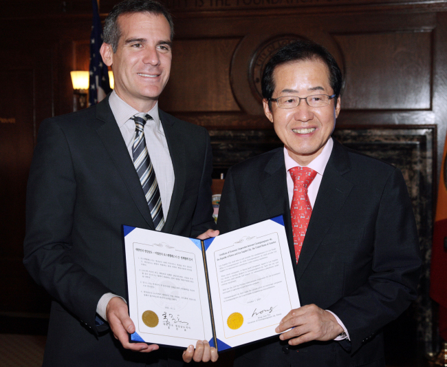South Gyeongsang Gov. Hong Joon-pyo (right) and Mayor of Los Angeles Eric Garcetti hold a certificate of an economic cooperation at the L.A. city hall on Tuesday.   (South Gyeongsang Province)