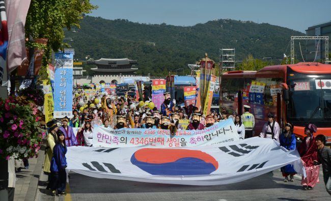 Performers wearing masks of Dangun, the legendary founding father of Korea, and other mythical characters lead a National Foundation Day parade on the street in front of Gwanghwamun, Seoul, Thursday. (Chung Hee-cho/The Korea Herald)