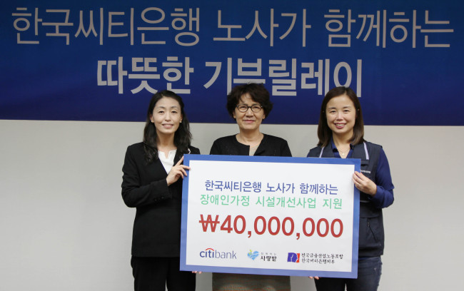 Citibank Korea’s communication division head Oh Young-ran (left) poses after delivering a donation of 40 million won ($36,000), jointly raised by labor and management, to social foundation Sarangbat at the financial firm’s headquarters in downtown Seoul on Friday.    Citigroup Korea