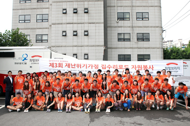 A student volunteer team organized by Hyundai E&C poses before participating in a project to repair disaster-prone houses.   (Hyundai E&C)
