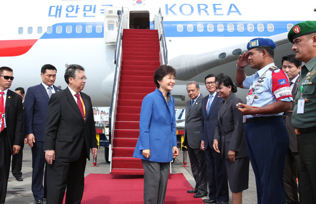 President Park Geun-hye meets with the welcoming delegates upon arriving in Bali, Indonesia, on Sunday to attend the APEC summit.   (Yonhap News)