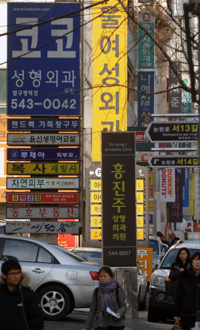 Signs advertising plastic surgery clinics are displayed on a street in Seoul. (Bloomberg)