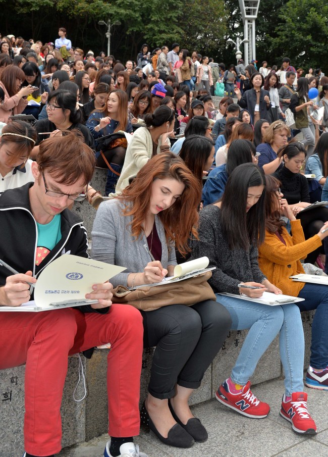 More than 2,000 foreign and overseas Korean students take part in a Korean essay contest at Yonsei University in Seoul on Monday ahead of Wednesday’s Hangeul Day.   (Lee Sang-sub/The Korea Herald)