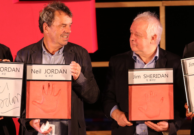 Irish filmmakers Neil Jordan (left) and Jim Sheridan pose for a photo after a hand printing event during the Busan International Film Festival in Busan, Sunday.   (Yonhap News)