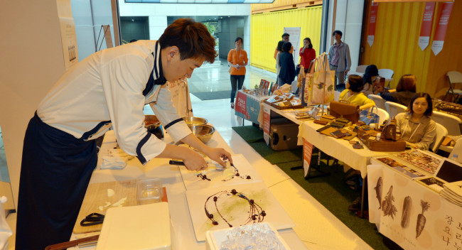 Chef Kim Yong-hui demonstrates creative plating at the Herald Design Market’s Food Deco Show. Kim Myung-sub/The Korea Herald