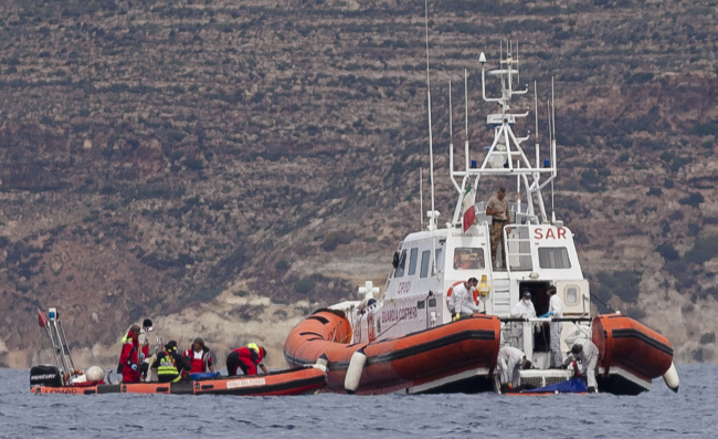 Italian Coast Guard personnel recover a body bag on their patrol boat in Lampedusa island, Italy, Tuesday.    AP-Yonhap News