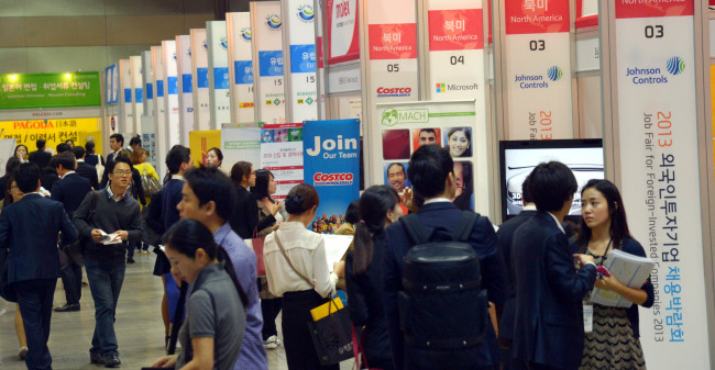 Jobseekers browse companies’ booths to get information on employment at the Job Fair for Foreign-invested Companies 2013 organized by the state-run Korea Trade-Investment Promotion Agency at Coex, southern Seoul on Thursday. About 110 foreign companies are participating in the event to recruit some 1,400 people during the two-day job fair.   (Kim Myung-sub/The Korea Herald)