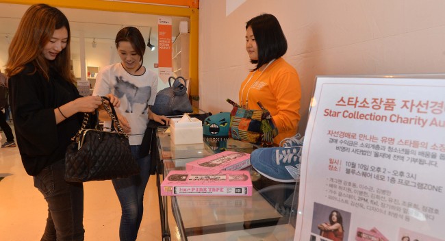 Visitors make a bid for items donated by celebrities at a charity auction held Thursday as part of Herald Design Week 2013 at exhibition space NEMO at Blue Square, Hannam-dong, Seoul.    (Lee Sang-sub/The Korea Herald)