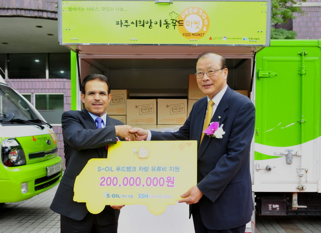 S-Oil CEO Nasser Al-Mahasher (left) poses with Cha Heung-bong, head of the Korea National Council on Social Welfare, after donating fuel coupons worth 200 million won to the food banks of farming and fishing villages on Thursday.   S-Oil