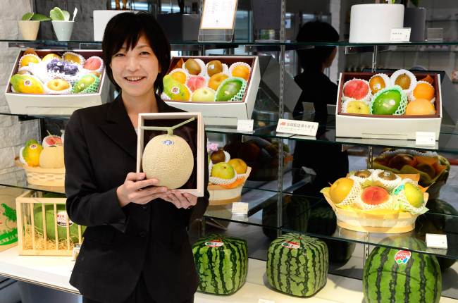 Miyuki Kaida, employee of Japan’s fruit shop chain Sun Fruits, introduces their high quality fruits at a shop in Tokyo. AFP-Yonhap News