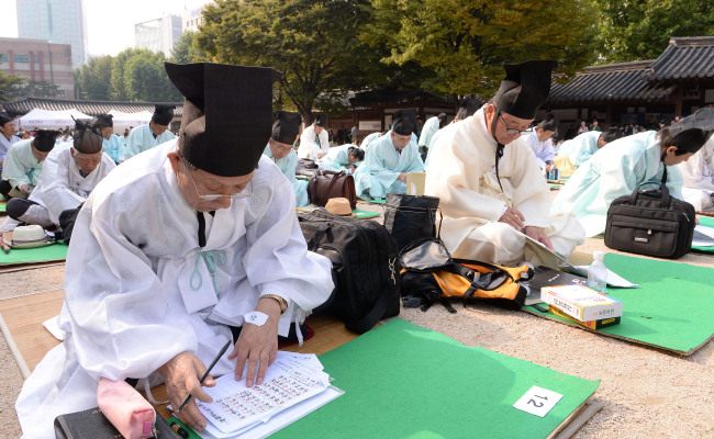 Applicants compose poems in Chinese in reenactment of Joseon era (1392-1910) tests to select senior officials, held by the Seoul Metropolitan Government in Unhyeongung Palace in the Jongno district on Sunday.   (Ahn Hoon/The Korea Herald)