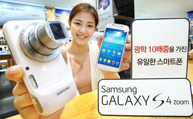 A model poses with Samsung Electronics’ “Galaxy S4 Zoom,” equipped with a 10x optical zoom lens, at a launch in Seoul on Monday.   (Samsung Elctronics)