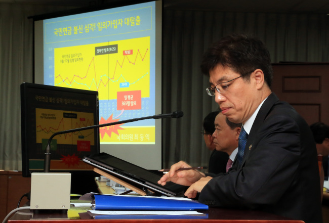 Vice Health and Welfare Minister Lee Young-chan reads audit reports released by lawmakers during a parliamentary session held at the ministry’s head office in Seoul on Monday.   (Yonhap News)