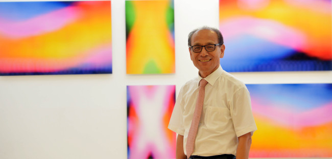 Han poses in front of his photographs on display at Gallery One in Seoul on Thursday.   (Kim Myung-sub/The Korea Herald)