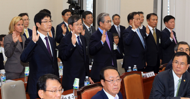 Mercedes-Benz Korea CEO Britta Seegern (left), BMW Korea CEO Kim Hyo-joon (third from left, standing) and other heads of foreign car brands take an oath at the audit session of the National Assembly’s National Policy Committee on Tuesday.   (Yonhap News)
